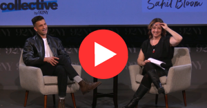 Two people converse on stage, seated on gray chairs. Both are smiling; one holds a paper. Background features “9XNY” logos. A large play button is overlaid.