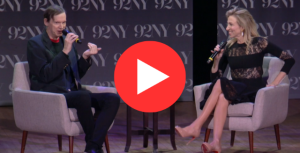 Two people are seated on stage, engaged in a lively conversation with microphones in hand. They are in front of a backdrop displaying "92NY."