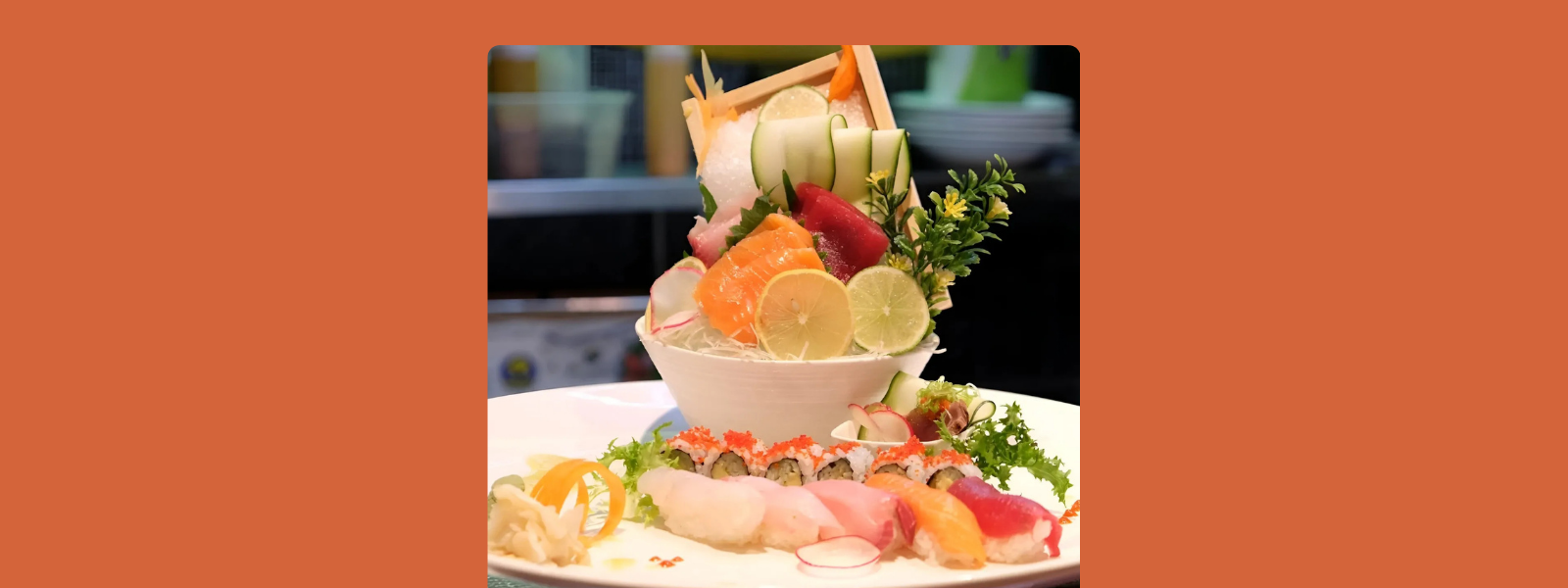 A colorful, artistic sushi platter featuring assorted sashimi, sushi rolls, and garnishes like lemon slices and greens on a white plate, conveying elegance.