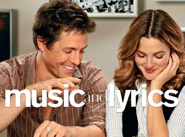 Man and woman sit closely, smiling warmly. Text "music and lyrics" overlays the image. Background features framed photos and music-themed decor. Romantic and lighthearted tone.