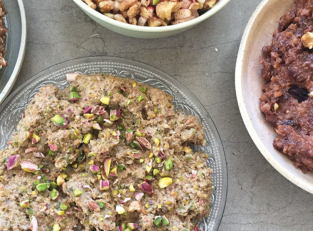 A variety of Persian sweets on a table: bowls of nutty and fruit-studded halva, and other sweet pastes, creating a warm, inviting atmosphere.