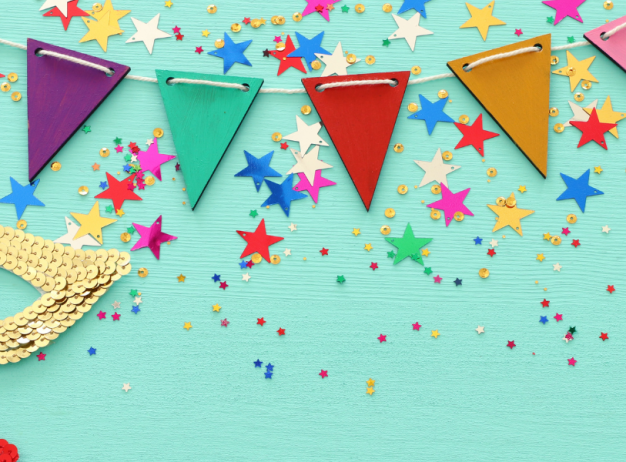 Festive image with colorful triangular banners and vibrant star-shaped confetti on a turquoise background. Sequined gold and red masks add a celebratory feel.