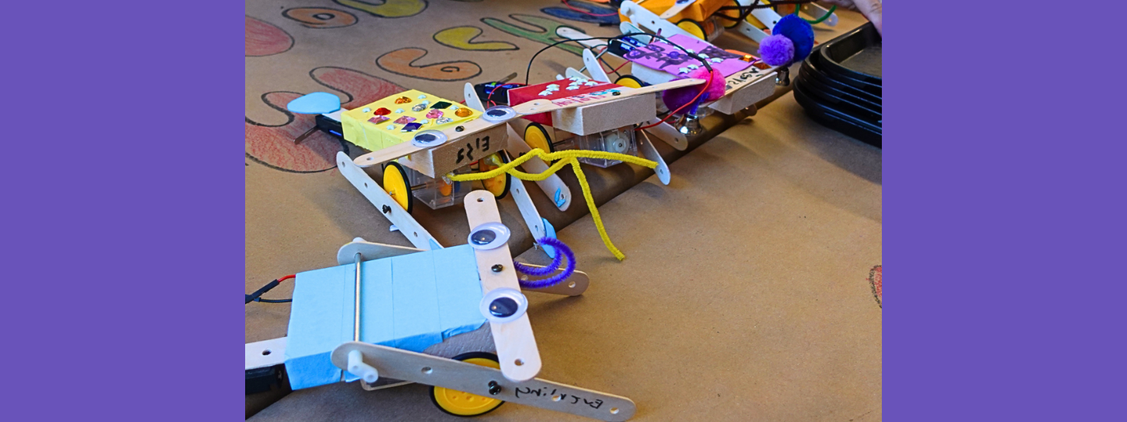 A colorful, custom-built robot made from popsicle sticks, googly eyes, and various small craft items on a table, conveying a fun and creative vibe.